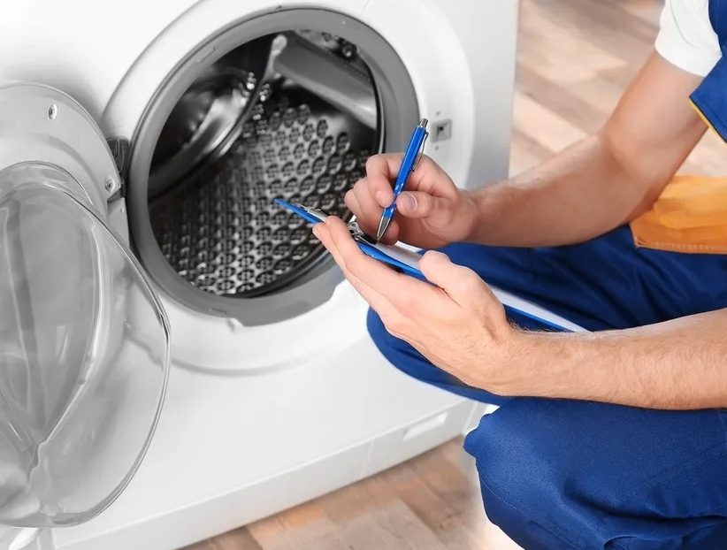 Tecnico effettua diagnosi su lavatrice a domicilio